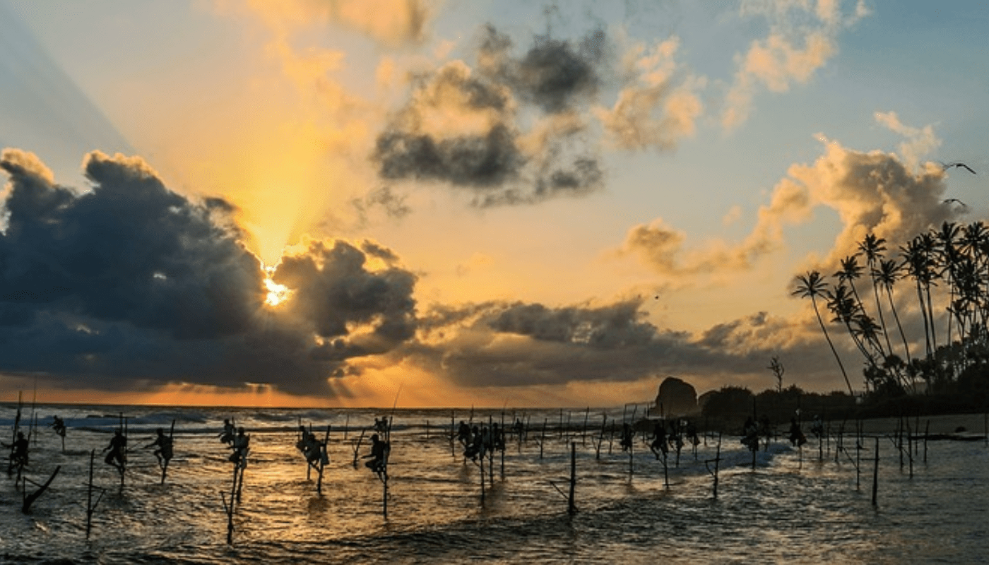 sri lanka - traditional stilt fishermen at sunset